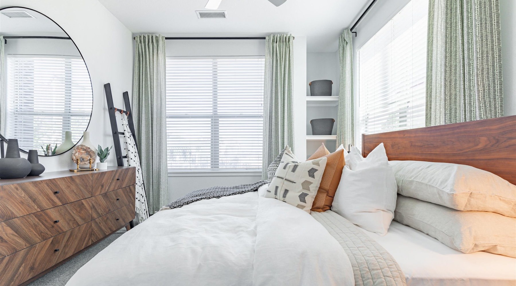 a bedroom with a bed, dresser and mirror
